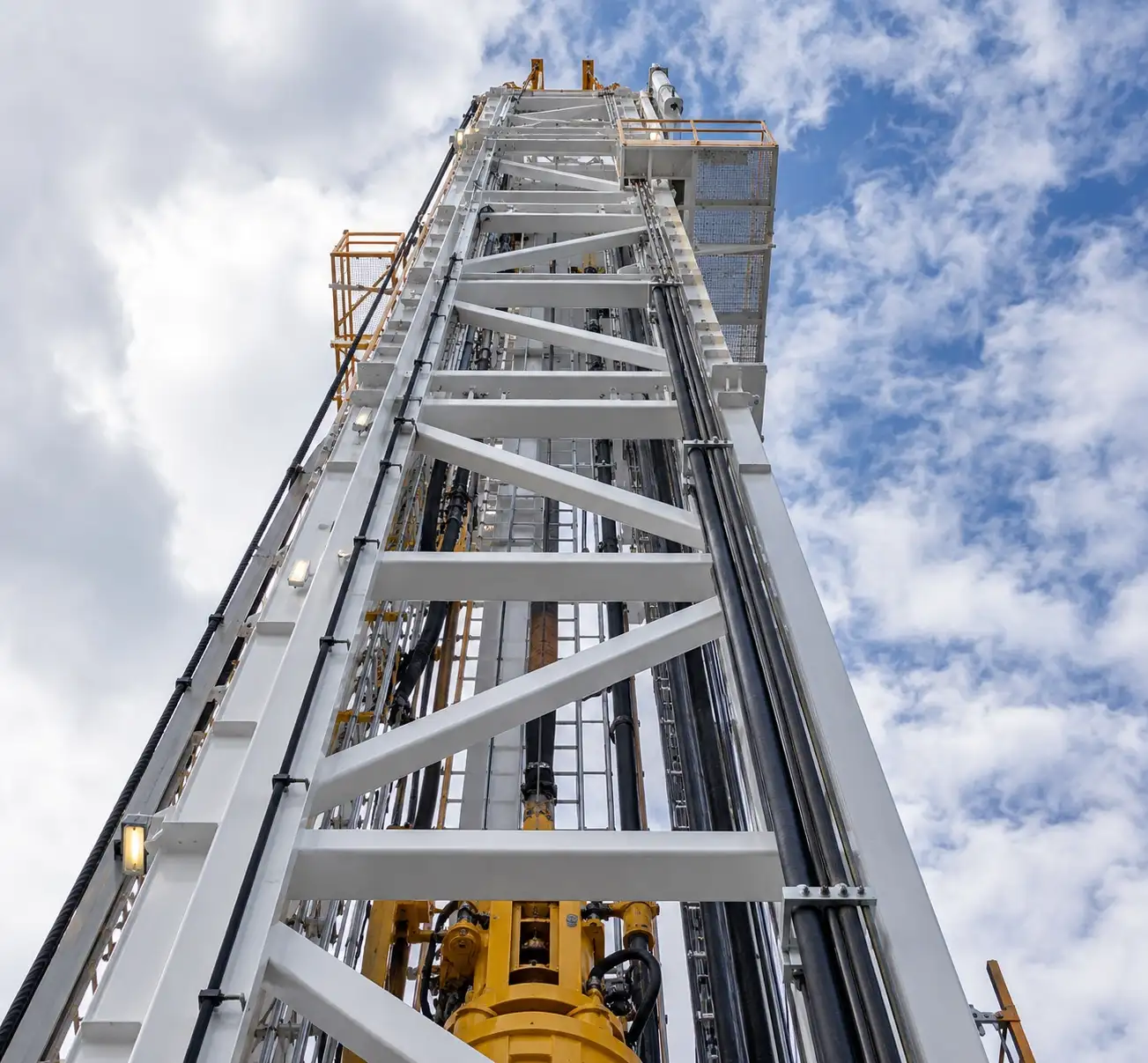 Upward view of an industrial drilling rig structure supported by DPES electrical and control systems